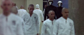 Movie still from “THX 1138” (1971), directed by George Lucas – A group of men in white lab coats and white helmets; Wide shot, Low angle