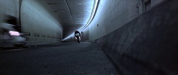 Movie still from “THX 1138” (1971), directed by George Lucas – A man riding a motorcycle down the side of a tunnel; Extreme Wide shot, Low angle