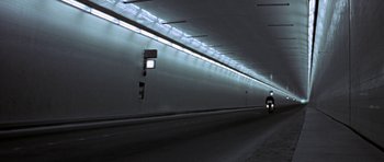 Movie still from “THX 1138” (1971), directed by George Lucas – A car driving down a street in a tunnel; Extreme Wide shot, Low angle