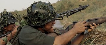 Movie still from “Tae Guk Gi: The Brotherhood of War” (2004), directed by Kang Je-kyu – A man wearing a helmet and holding a rifle; Medium shot, Low angle