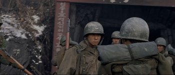 Movie still from “Tae Guk Gi: The Brotherhood of War” (2004), directed by Kang Je-kyu – A group of men in military fatigues and helmets; Close Up shot, Over the shoulder angle