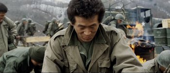 Movie still from “Tae Guk Gi: The Brotherhood of War” (2004), directed by Kang Je-kyu – A man in a military uniform is looking down at his face; Close Up shot, High angle