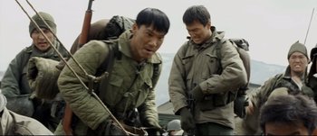 Movie still from “Tae Guk Gi: The Brotherhood of War” (2004), directed by Kang Je-kyu – A couple of men standing next to each other on top of a hill; Medium shot, Over the shoulder angle