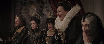 Movie still from “Tale of Tales” (2015), directed by Matteo Garrone – A group of women dressed in black and gold clothing; Medium shot, Over the shoulder angle