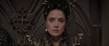 Movie still from “Tale of Tales” (2015), directed by Matteo Garrone – A person wearing a costume holding an umbrella; Close Up shot, Over the shoulder angle