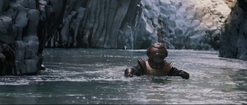 Movie still from “Tale of Tales” (2015), directed by Matteo Garrone – A person in a body of water near a waterfall; Wide shot, High angle