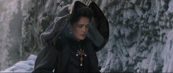 Movie still from “Tale of Tales” (2015), directed by Matteo Garrone – A woman in a black dress with a cross on her head; Close Up shot, High angle
