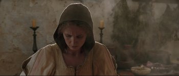 Movie still from “Tale of Tales” (2015), directed by Matteo Garrone – A woman wearing a hooded shirt looking down at her face; Medium shot, Low angle