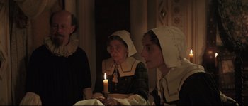 Movie still from “Tale of Tales” (2015), directed by Matteo Garrone – A group of people sitting next to each other holding a candle; Medium shot, Over the shoulder angle