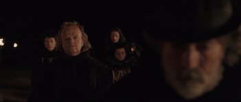 Movie still from “Tale of Tales” (2015), directed by Matteo Garrone – A group of people standing in a dark room; Medium shot, Over the shoulder angle