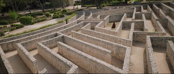 Movie still from “Tale of Tales” (2015), directed by Matteo Garrone – A person is sitting in the middle of a maze; Extreme Wide shot, High angle