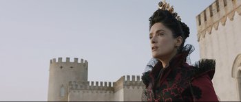 Movie still from “Tale of Tales” (2015), directed by Matteo Garrone – A woman in a black and red dress with a castle in the background; Close Up shot, Low angle