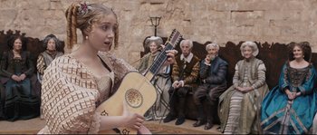 Movie still from “Tale of Tales” (2015), directed by Matteo Garrone – A woman holding a guitar in front of an audience; Medium shot, Over the shoulder angle
