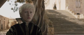Movie still from “Tale of Tales” (2015), directed by Matteo Garrone – A woman in a black and gold outfit standing in front of a staircase; Medium shot, High angle