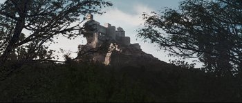 Movie still from “Tale of Tales” (2015), directed by Matteo Garrone – A castle on top of a mountain with trees in the foreground; Extreme Wide shot, Low angle