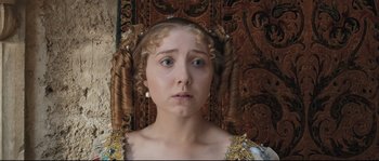 Movie still from “Tale of Tales” (2015), directed by Matteo Garrone – A young woman in a renaissance dress looking at the camera; Close Up shot, Over the shoulder angle