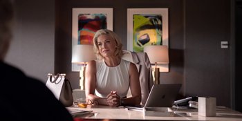 Movie still from “Ted Lasso” (2020), created by Brendan Hunt – A woman sitting at a desk in front of a computer; Medium shot, Over the shoulder angle