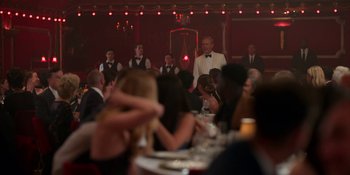 Movie still from “Ted Lasso” (2020), created by Brendan Hunt – A group of people sitting at a dinner table; Wide shot, Over the shoulder angle