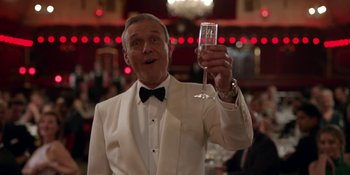 Movie still from “Ted Lasso” (2020), created by Brendan Hunt – An older man in a tuxedo holding a glass of champagne; Medium shot, Low angle