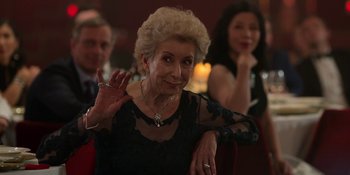 Movie still from “Ted Lasso” (2020), created by Brendan Hunt – An older woman in a black dress waving; Medium shot, Over the shoulder angle