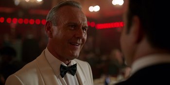 Movie still from “Ted Lasso” (2020), created by Brendan Hunt – An older man wearing a white suit and black bow tie; Close Up shot, Over the shoulder angle