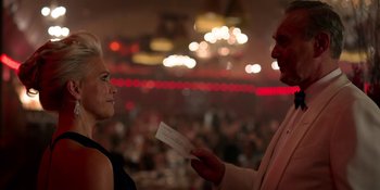 Movie still from “Ted Lasso” (2020), created by Brendan Hunt – A man and a woman in a room with lights in the background; Medium shot, Over the shoulder angle