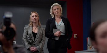 Movie still from “Ted Lasso” (2020), created by Brendan Hunt – Two women standing next to each other holding papers; Medium shot, Low angle