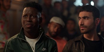 Movie still from “Ted Lasso” (2020), created by Brendan Hunt – A group of people standing in a room; Close Up shot, Over the shoulder angle