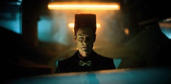 Movie still from “Altered Carbon” (2018), created by Laeta Kalogridis – A man in a suit and bow tie with a hat on top of his head; Close Up shot, Low angle