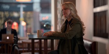 Movie still from “Ted Lasso” (2020), created by Brendan Hunt – A woman sitting at a table with a cup of coffee; Medium shot, Over the shoulder angle