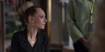 Movie still from “Ted Lasso” (2020), created by Brendan Hunt – A woman wearing a black shirt and a gold necklace; Close Up shot, Over the shoulder angle