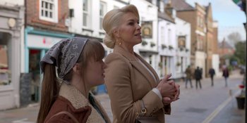 Movie still from “Ted Lasso” (2020), created by Brendan Hunt – Two women standing on a sidewalk near each other; Medium shot, Over the shoulder angle