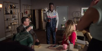 Movie still from “Ted Lasso” (2020), created by Brendan Hunt – A group of people sitting around a table; Medium shot, Over the shoulder angle