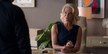 Movie still from “Ted Lasso” (2020), created by Brendan Hunt – A woman sitting at a table writing on a piece of paper; Medium shot, Over the shoulder angle