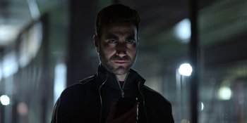 Movie still from “Ted Lasso” (2020), created by Brendan Hunt – A man with headphones looking at a cell phone; Close Up shot, Low angle