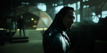 Movie still from “Altered Carbon” (2018), created by Laeta Kalogridis – A man in a leather jacket standing in a dark room; Close Up shot, Low angle