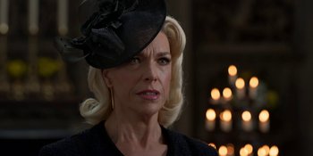 Movie still from “Ted Lasso” (2020), created by Brendan Hunt – An older woman wearing a black hat and a black jacket; Close Up shot, Over the shoulder angle