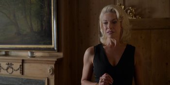 Movie still from “Ted Lasso” (2020), created by Brendan Hunt – A woman in a black dress looking at her reflection in a mirror; Medium shot, Over the shoulder angle