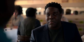 Movie still from “Ted Lasso” (2020), created by Brendan Hunt – A person wearing a suit and tie; Close Up shot, Over the shoulder angle