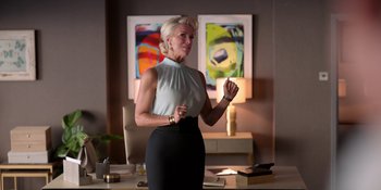 Movie still from “Ted Lasso” (2020), created by Brendan Hunt – A woman standing in front of a table in front of a painting; Medium shot, Low angle