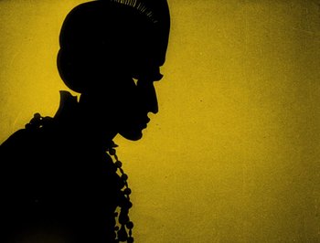 Movie still from “The Adventures of Prince Achmed” (1926), directed by Lotte Reiniger – A silhouette of a woman in a black dress; Extreme Close Up shot, Low angle