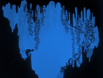 Movie still from “The Adventures of Prince Achmed” (1926), directed by Lotte Reiniger – A silhouette of a cave with a monkey climbing on the side; Extreme Wide shot, Overhead angle