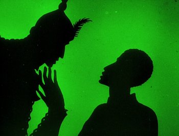 Movie still from “The Adventures of Prince Achmed” (1926), directed by Lotte Reiniger – A man and a woman are silhouetted against a green background; Medium shot, Overhead angle