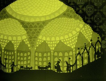 Movie still from “The Adventures of Prince Achmed” (1926), directed by Lotte Reiniger – A shadow puppet show is shown in a yellow light; Extreme Wide shot, Low angle