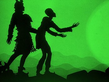 Movie still from “The Adventures of Prince Achmed” (1926), directed by Lotte Reiniger – A shadow of a man and a woman dancing in front of a green background; Wide shot, Low angle