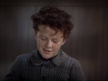 Movie still from “The Adventures of Tom Sawyer” (1938), directed by Norman Taurog – A young boy with curly brown hair is smiling; Close Up shot, High angle