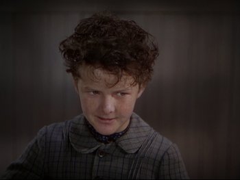 Movie still from “The Adventures of Tom Sawyer” (1938), directed by Norman Taurog – A young boy with curly hair wearing a checkered shirt; Close Up shot, High angle