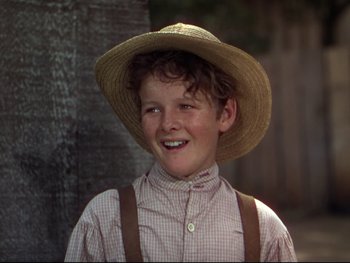 Movie still from “The Adventures of Tom Sawyer” (1938), directed by Norman Taurog – A young boy wearing a straw hat and suspenders; Close Up shot, High angle