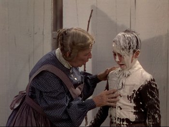 Movie still from “The Adventures of Tom Sawyer” (1938), directed by Norman Taurog – An older woman and a young boy covered in powdery substance; Medium shot, Over the shoulder angle