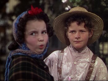 Movie still from “The Adventures of Tom Sawyer” (1938), directed by Norman Taurog – Two young children wearing hats posing for a picture; Close Up shot, High angle